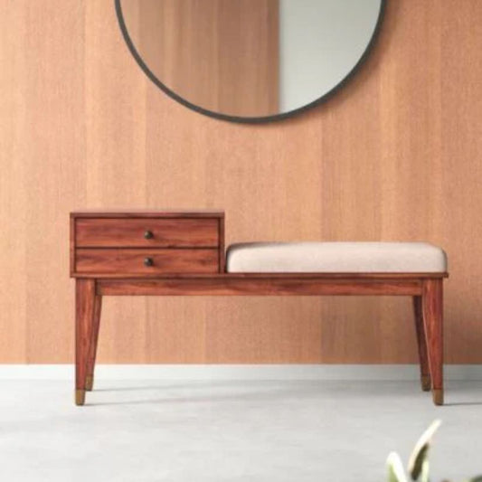 A brown fabric bench with beige cushion, with a wooden frame and four square legs, placed against a wall with a large circular mirror above it.