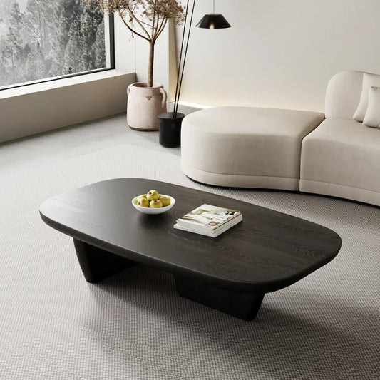 Modern living room with a dark wooden coffee table, white sofa, and decorative elements.