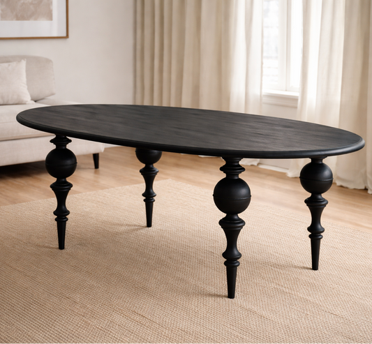 Black oval table with decorative legs in a living room setting
