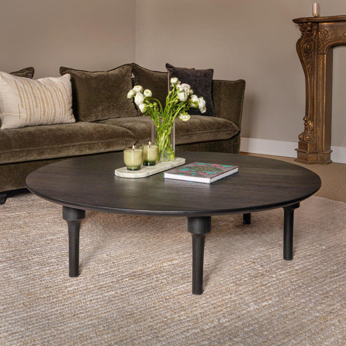 minimalist Living room with a brown sofa, round wooden coffee table, and decorative items.