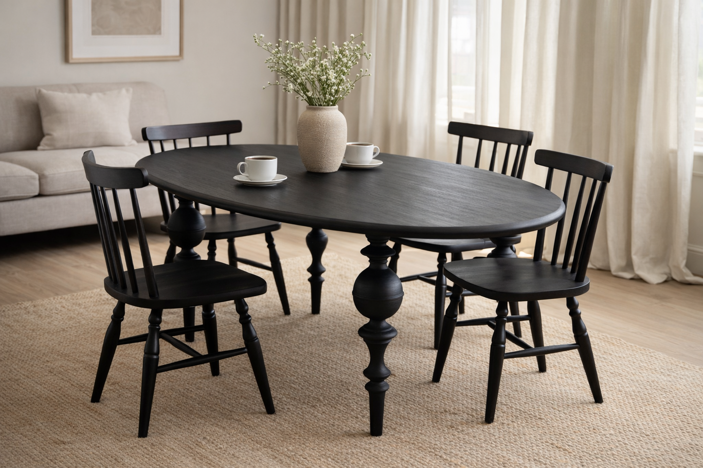 Dining room with a black oval table and chairs, featuring a vase of flowers and cups.